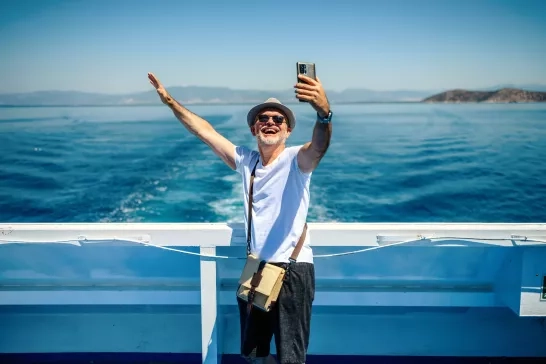 Happy senior man taking a selfie on a cruise.