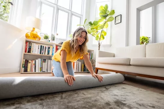 women rolling a rug