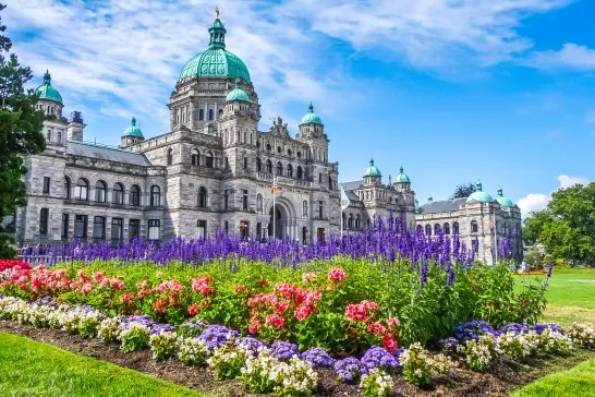 Historic parliament building in Victoria with colorful flowers, BC