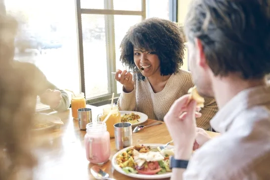 A woman eating with friends at a restaurant
