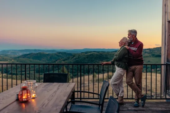 A senior couple admiring the sunset overtop the mountains.