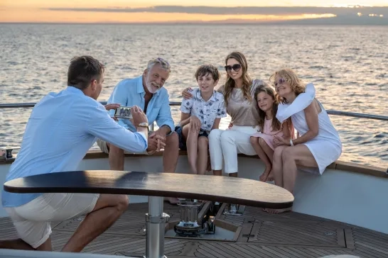 Man taking photo of happy multi-generation family with smartphone