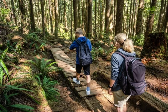 Mother and son hiking in a forest in British Columbia