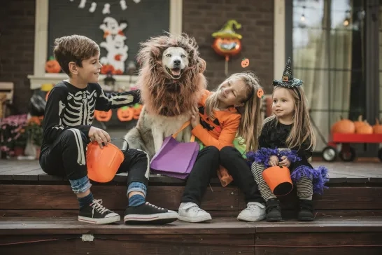 kids at home with dog, everyone is dressed for Halloween