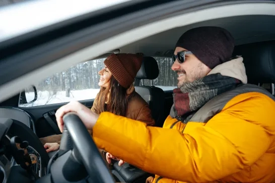  couple sitting in car in winter clothes