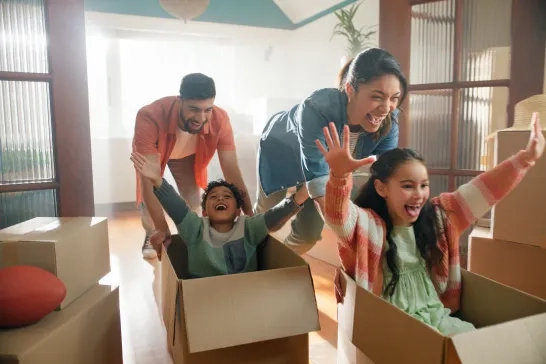 Happy family, parents and children in boxes in new home or playing game