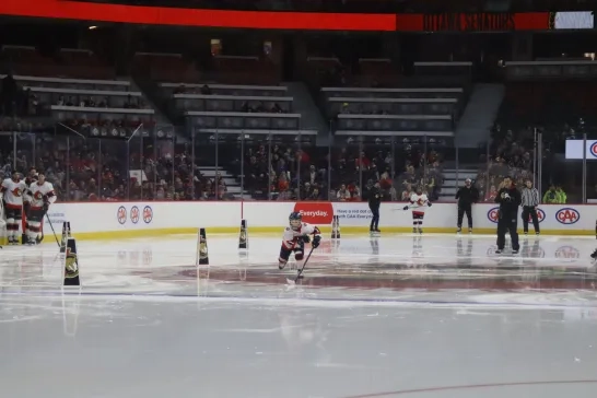 a young skater in hockey gear skates towards the camera at the Canadian Tire Centre