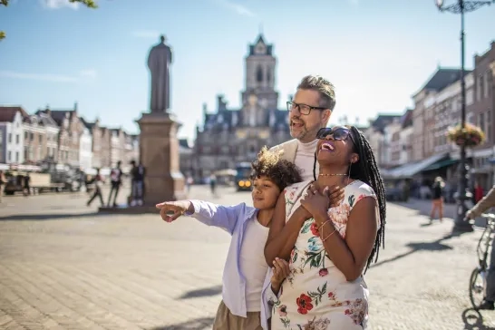 A family of three laughing together while travelling. 