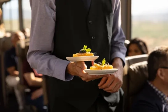 A host serving some dishes onboard Canyon Spirit