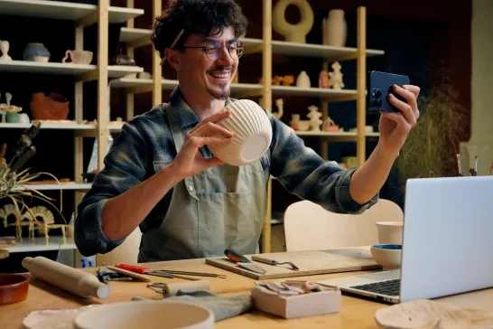 Small business owner photographing pottery