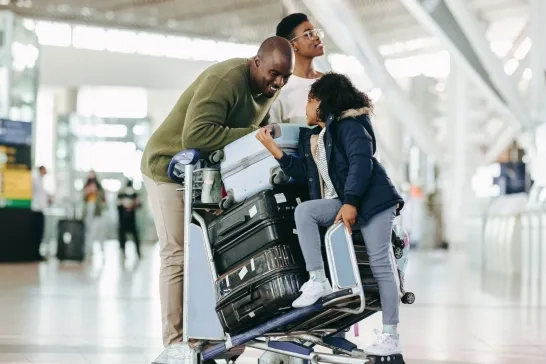 family with luggage waiting at airport