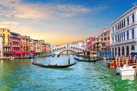 Venice Grand Canal, view of the Rialto Bridge and gondoliers, Italy