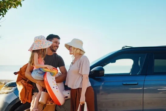 Family next to car getting ready for a day at the beach