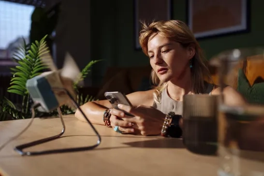 woman on phone in front of a fan