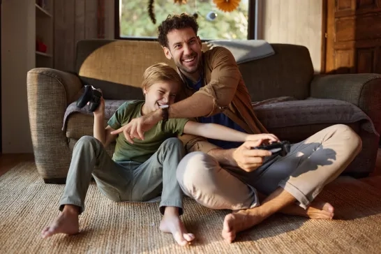 Man playing games with son indoors