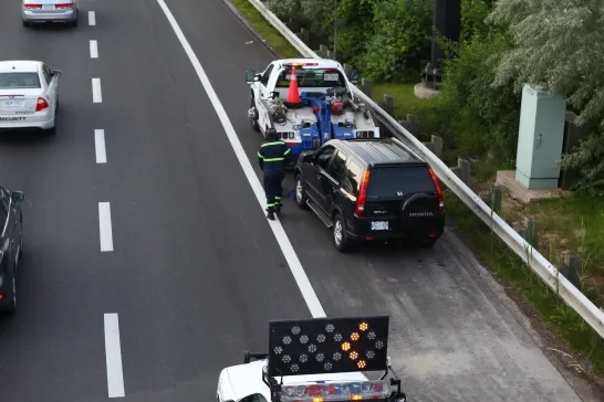 Tow truck driver on the side of the road.