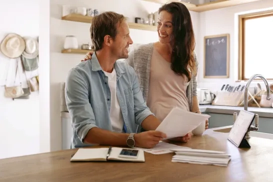 couple looking at paperwork in kitchen