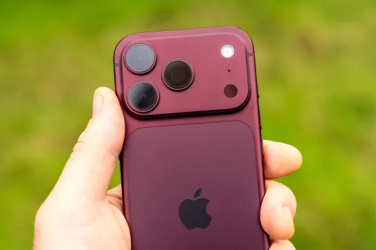 Detail of a new Burgundy iPhone 18 Pro smart phone being held outdoors