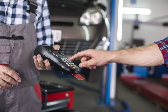 Customer paying with credit card machine payment at car service