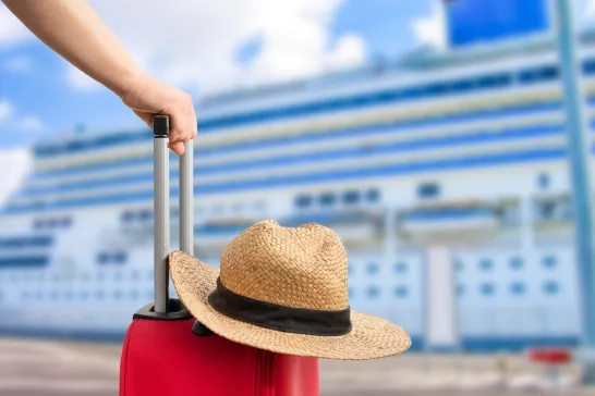 a red suitcase near a cruise ship