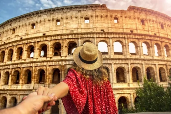 Woman dressed in red outside the Colosseum in Rome, Italy  