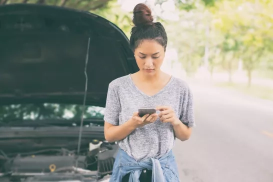 Young woman on phone with car breakdown
