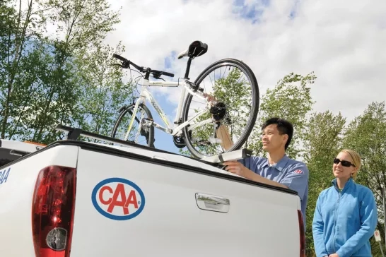 CAA roadside technician loading a bicycle onto a CAA light service truck