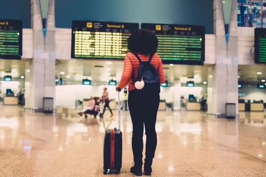 Woman standing at the airport with her luggage