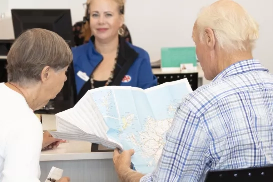 Couple browsing a map at a CAA Travel store