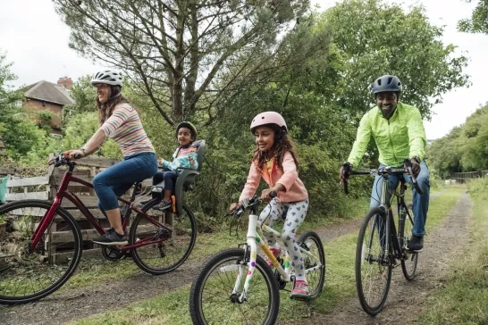 Family biking through a trail