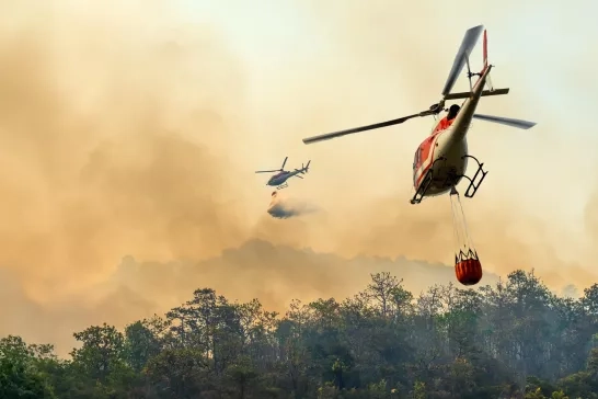 A helicopter carrying water to a wildfire