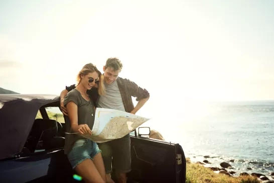 Couple looking at a map outside their car