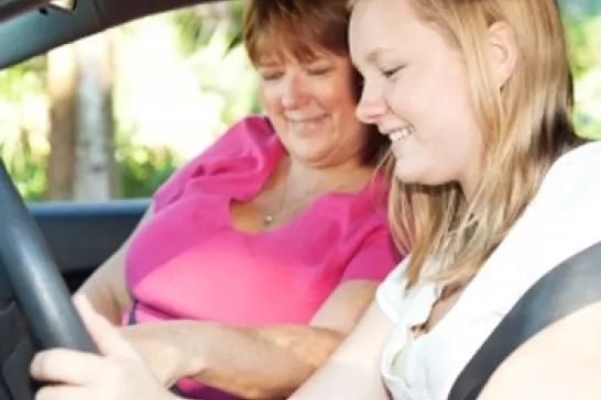 A female student driver with female instructor in a car