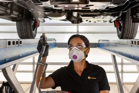 Female Technician Broadspraying Underside