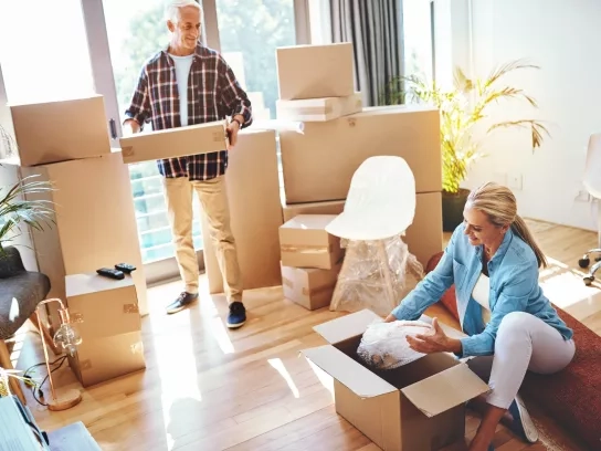 Couple moving into new home surrounded by boxes