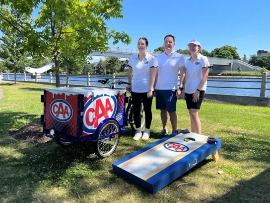 a team of three CAA representatives posing beside a CAA branded icecream bike