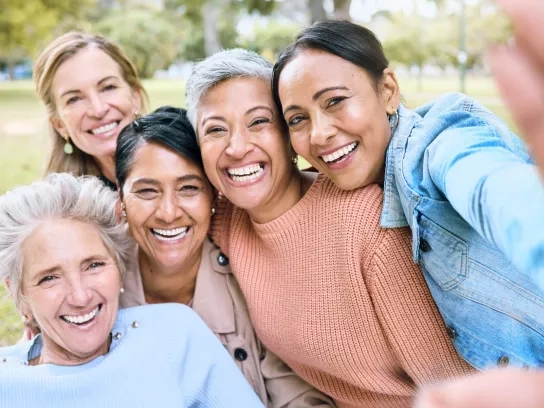 Friend group taking photo together outdoors in the sun