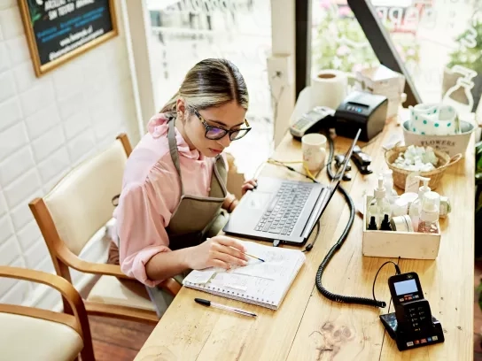 Young business owner using laptop at retail shop