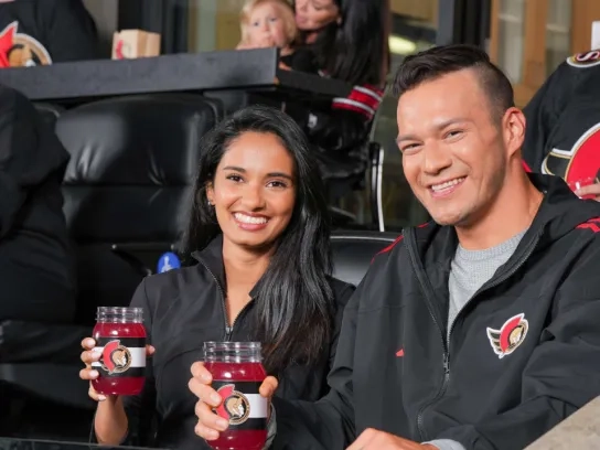Two people enjoying their drinks at the Ottawa Senator suite