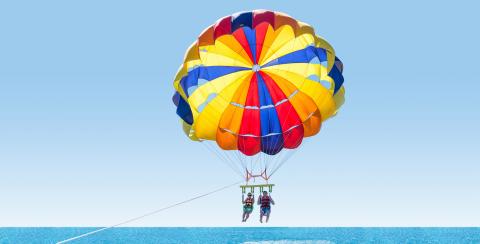 Happy couple Parasailing on Tropical Beach in summer