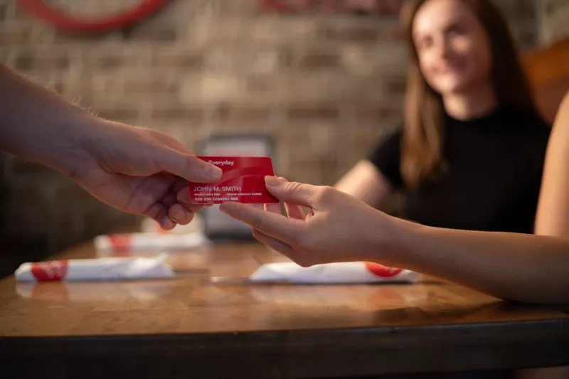 CAA Member hands Everyday Membership card to Swiss Chalet server