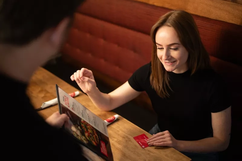 CAA Member dining out at a restaurant using their CAA card to save