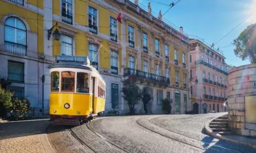 Famous yellow tram n the narrow streets of Alfama district in Lisbon, Portugal 