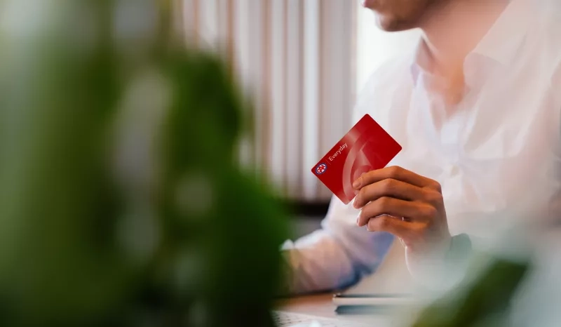 Person at desk holding membership card