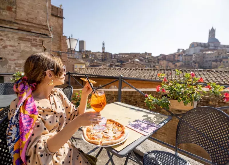 Woman eating pizza while on a vacation in Europe