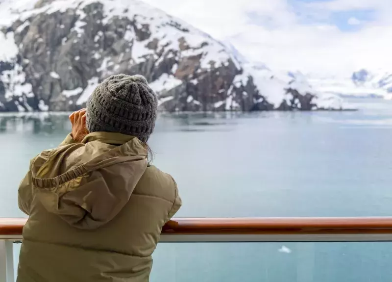 Woman on a cruise ship in Alaska looking at the scenery