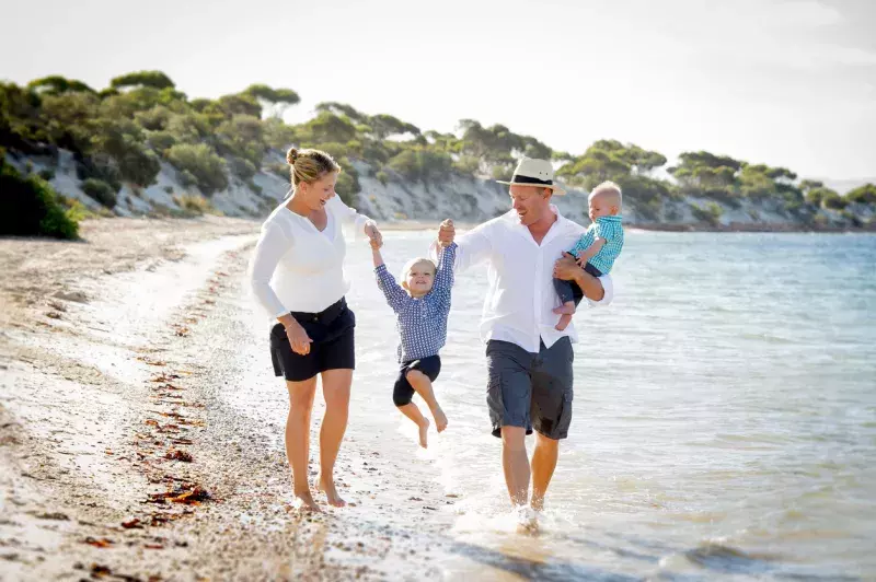 a family with two sons enjoying on the beach