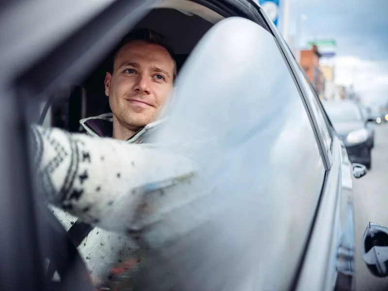 man driving car with window rolled down