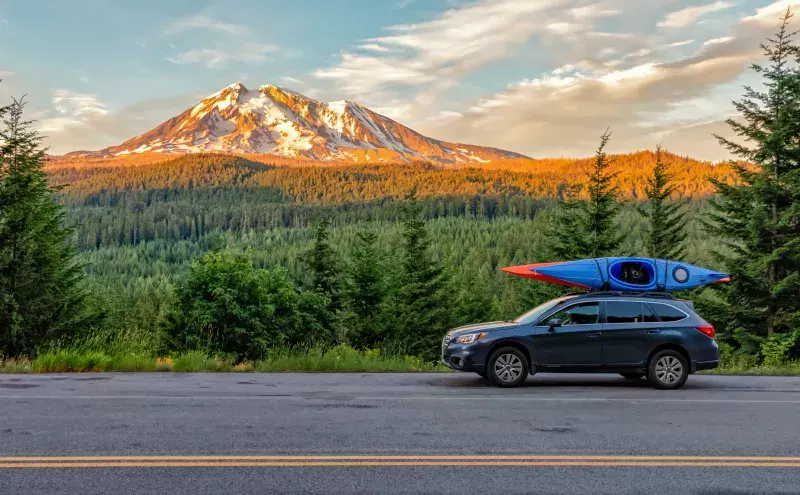 Gifford Pinchot National Forest, Washington - July 13, 2018: SUV with Kayaks in front of Mt. Adams at sunset