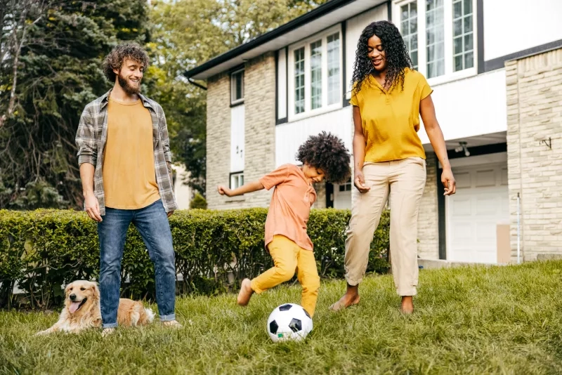 Couple and their daughter spending quality time together outside on their lawn.